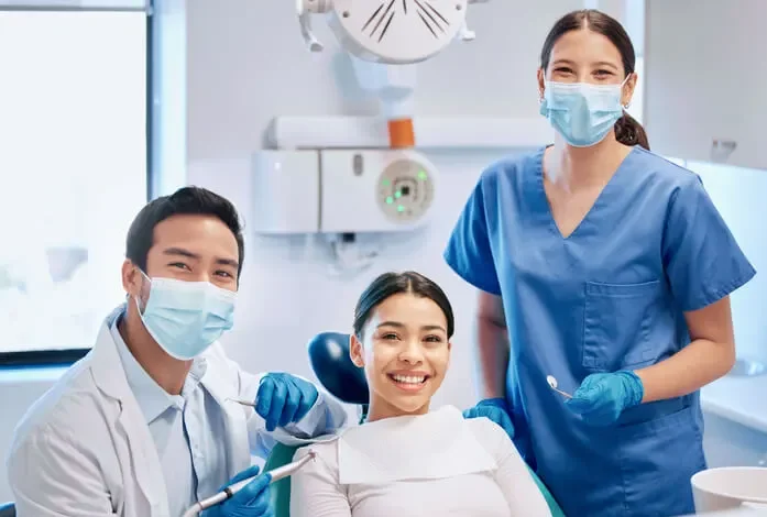 A dental team with a patient in the practice